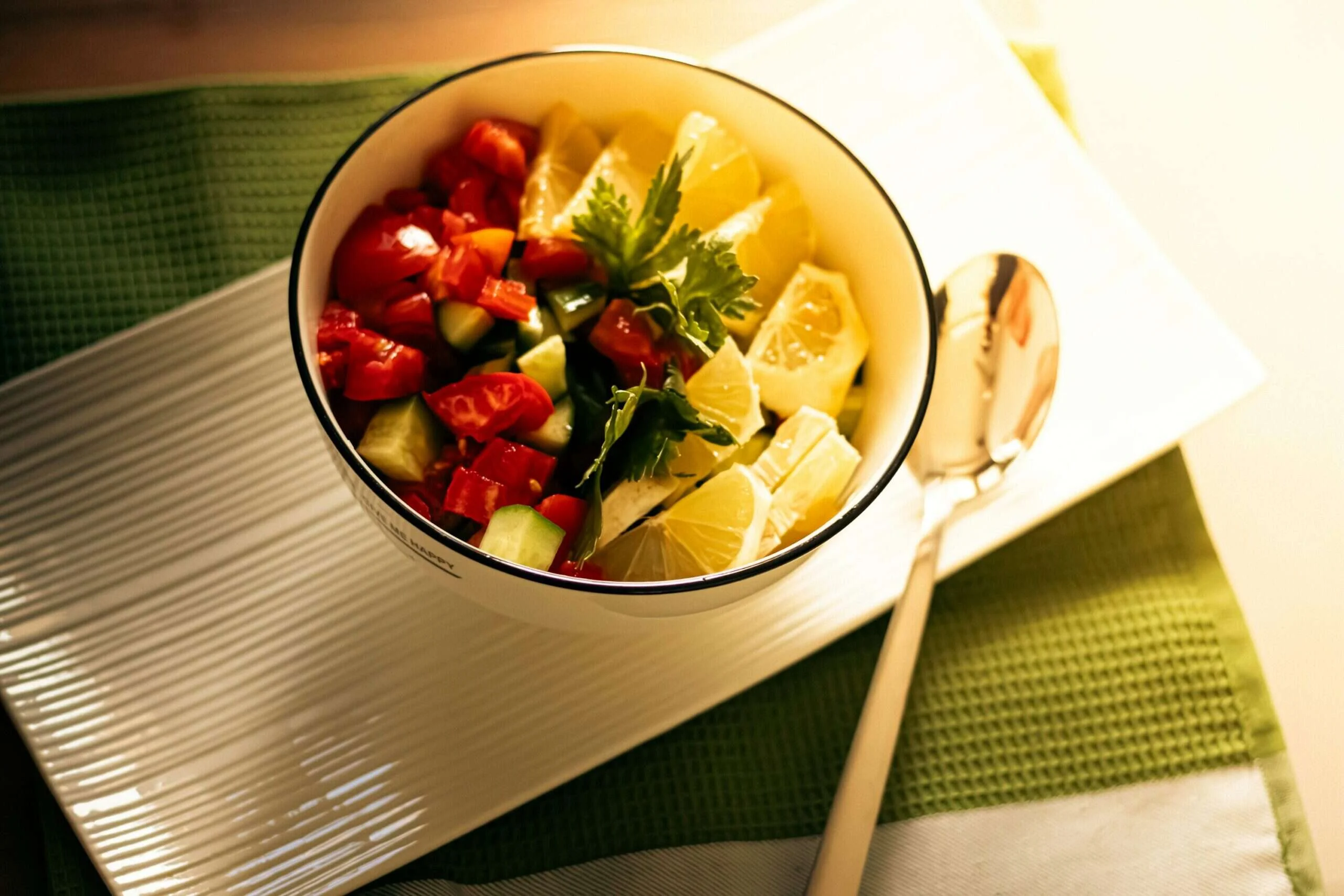 Fresh vegetables and citrus arranged in a bowl